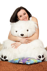 Image showing Smiling girl sitting in an embrace with a teddy bear