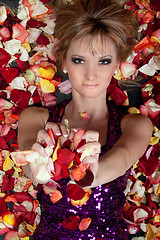 Image showing charming young blonde lying in rose petals