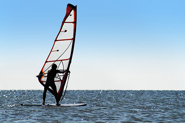 Image showing Silhouette of a windsurfer on the blue sea