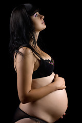 Image showing Pregnant young brunette in lingerie. Isolated