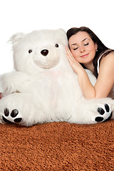 Image showing Girl asleep leaning against a teddy bear