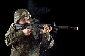 Image showing Alerted soldier keeping a smoking gun