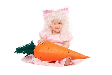 Image showing Funny baby girl plays with a carrot