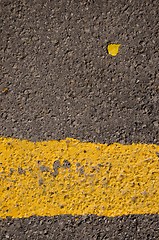 Image showing Asphalt closeup yellow road mark small birch leaf 