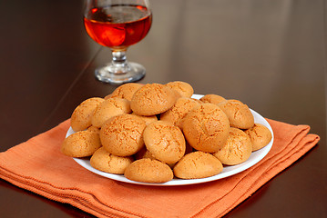 Image showing A plate of crisp Amaretti cookies with snifter of Amaretto in ba