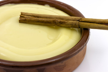 Image showing clay bowl, tasty dessert custard and cinnamon