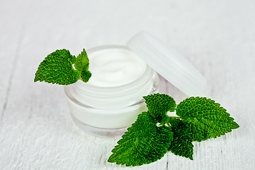 Image showing face cream in glass jar with green leaf of urtica 