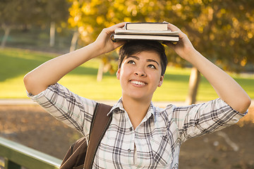 Image showing Mixed Race Female Student Holding Books on Her Head
