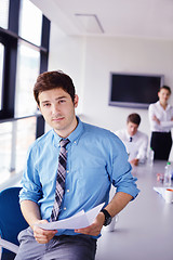Image showing business man  on a meeting in offce with colleagues in backgroun