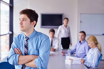 Image showing business man  on a meeting in offce with colleagues in backgroun