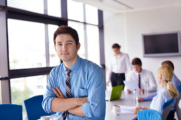 Image showing business man  on a meeting in offce with colleagues in backgroun