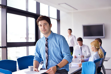 Image showing business man  on a meeting in offce with colleagues in backgroun