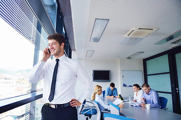 Image showing business man  on a meeting in offce with colleagues in backgroun