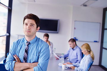 Image showing business man  on a meeting in offce with colleagues in backgroun