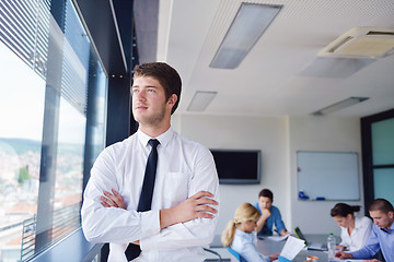 Image showing business man  on a meeting in offce with colleagues in backgroun