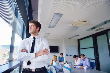 Image showing business man  on a meeting in offce with colleagues in backgroun