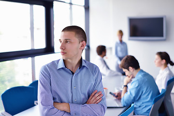 Image showing business man  on a meeting in offce with colleagues in backgroun