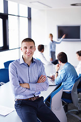 Image showing business man  on a meeting in offce with colleagues in backgroun