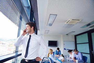 Image showing business man  on a meeting in offce with colleagues in backgroun