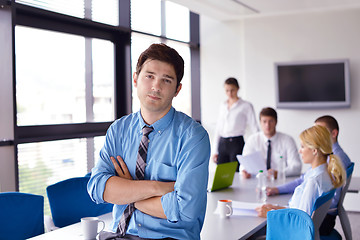 Image showing business man  on a meeting in offce with colleagues in backgroun