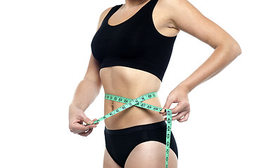 Image showing Fit woman measuring her waist, cropped image