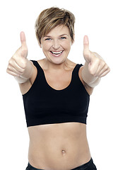 Image showing Excited attractive fit lady showing double thumbs up