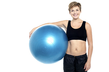 Image showing An attractive fit lady holding blue pilates ball