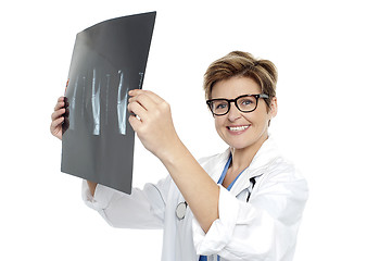 Image showing Experienced female doctor examining x-ray report