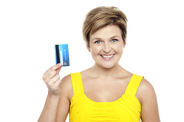 Image showing Cheerful woman holding up her cash card