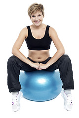 Image showing Fitness woman relaxing on exercise ball