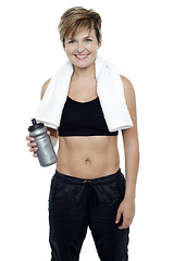 Image showing Charming fit lady holding up a bottle of water