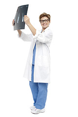 Image showing Smiling middle aged doctor holding up x-ray sheet