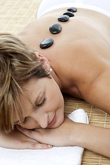 Image showing Pretty woman enjoying hot stone therapy