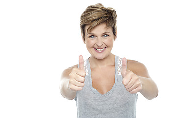 Image showing Excited middle aged lady showing double thumbs up