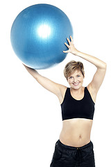 Image showing A healthy woman lifting big swiss ball