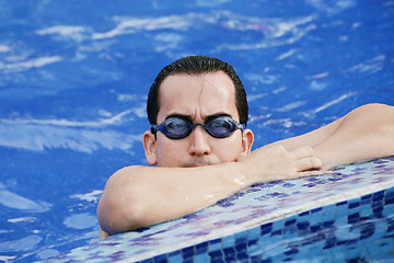 Image showing Male Swimmer resting after several laps in the indoor swimming p