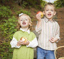 Image showing Adorable Children Eating Red Apples Outside