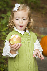 Image showing Adorable Child Girl Eating Red Apple Outside