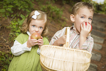 Image showing Adorable Children Eating Red Apples Outside