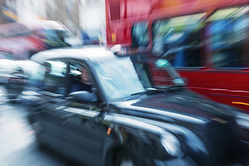 Image showing Motion blur picture of Black Cab and Red Double Decker Bus in th