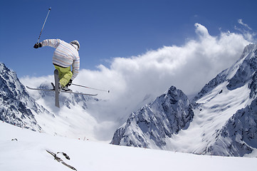 Image showing Freestyle ski jumper with crossed skis in high mountains
