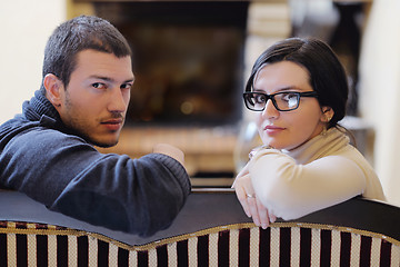 Image showing Young romantic couple sitting and relaxing in front of fireplace