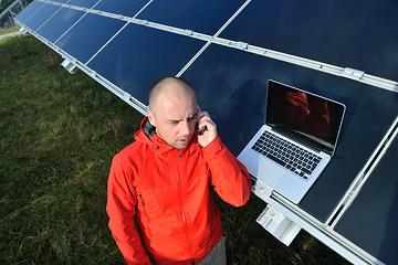 Image showing engineer using laptop at solar panels plant field