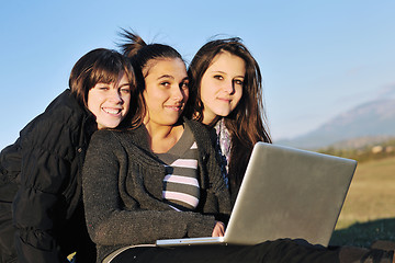 Image showing group of teens working on laptop outdoor