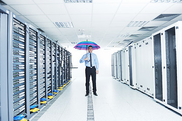 Image showing businessman hold umbrella in server room