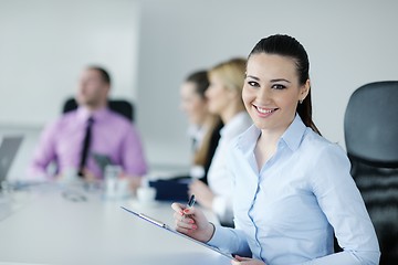 Image showing business woman standing with her staff in background