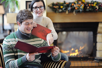 Image showing Young romantic couple sitting and relaxing in front of fireplace