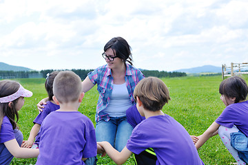 Image showing happy kids group with teacher in nature