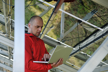 Image showing engineer using laptop at solar panels plant field