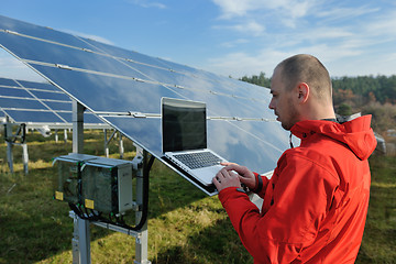 Image showing engineer using laptop at solar panels plant field